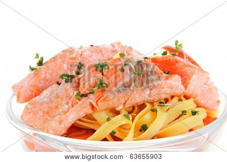 fresh fried natural pink salmon on italian traditional tagliatelle backed with tomato and vegetables isolated over white background