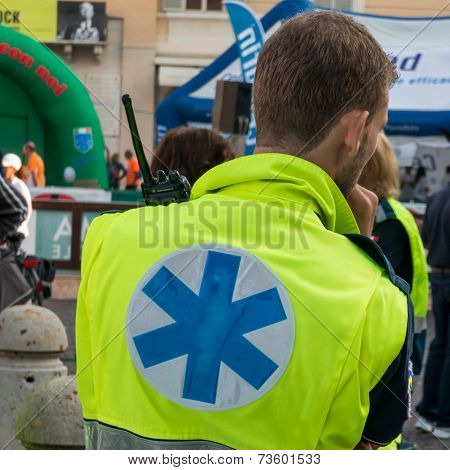 Paramedic with radio equipment wait for call; blue and yellow dressed
