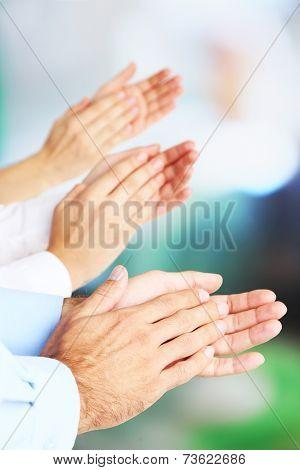 Clapping hands on bright background