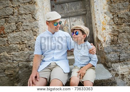 Happy father and son having rest outdoors in city