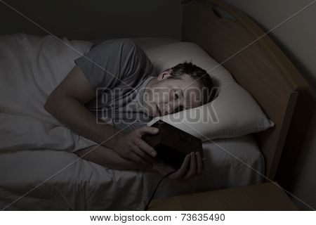 Mature Man Checking Time While Trying To Sleep