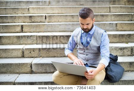 Hipster businessman with laptop