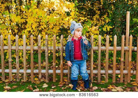 Autumn portrait of acute toddler boy wearing funny hat