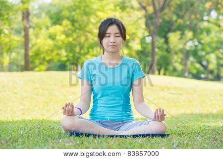 Asian Woman Practicing Yoga,breath Retention Pose, In Park
