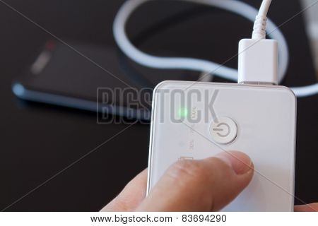 Male Hand Is Holding Power Bank Is Charging Smartphone