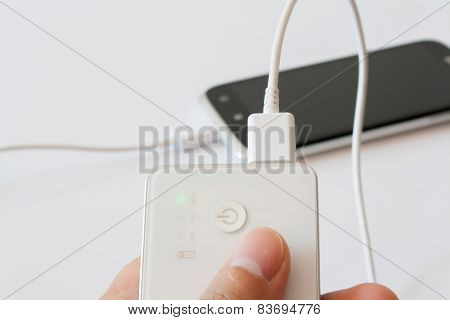 Male Hand Is Holding Power Bank Is Charging Smartphone