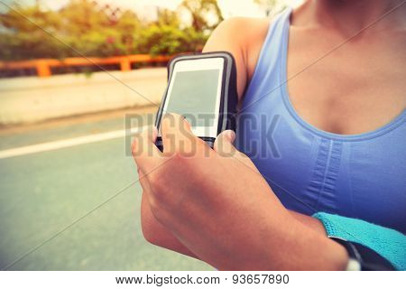 Runner athlete listening to music from smart phone mp3