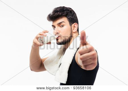 Fitness man drinking milk and showing thumb up isolated on a white background