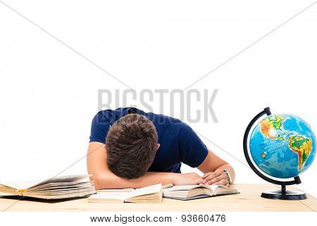 Tired male student sleeping on the table with books and globe isolated on a white background