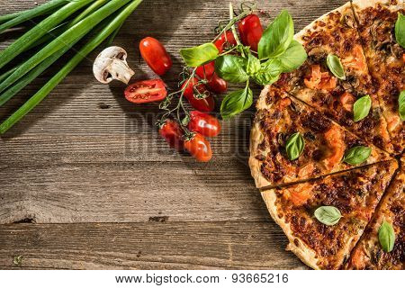 Vegetarian italian pizza with mushrooms on a wooden background with space for text