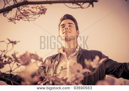 Good looking male model at couuntryside, among flowers
