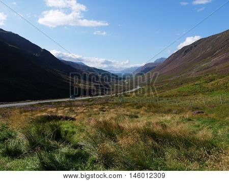 Winding open road through a valley in the Scottish highlands