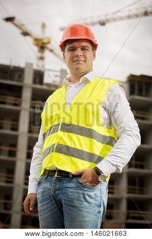 Portrait of smiling construction engineer in hardhat looking at camera