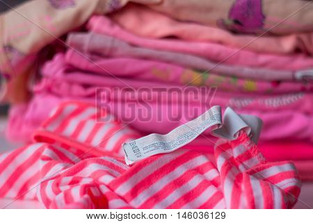 Pile of colorful clothing prepared for washing washing label visible