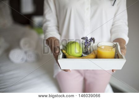 Maid with Tray with breakfast in a hotel room