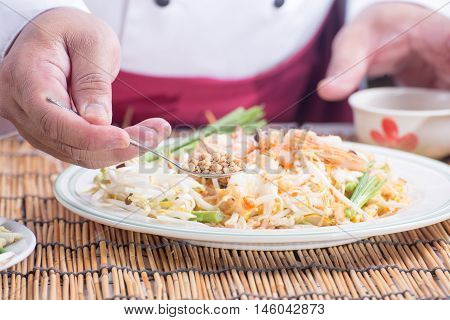 Chef decorated Pad Thai Menu with minced Peanut bean / cooking Pad Thai concept