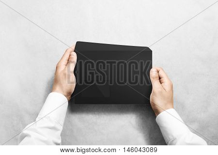 Black blank envelope mock up holding in hand. Empty letter with transparent window design mockup. Message template presentation. Person opening clear mail.