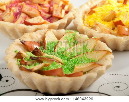 Small apple tartelettes with decoration. Horizontal shot