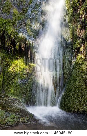 Beautiful slow shutter image of green waterfall, suitable for wallpaper. Vertical image.