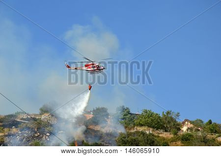 August 21 2016-Monti Prenestini-Castel San Peter- Roma-Lazio-Italy-the helicopter of the fire brigade to put out an arson attack on the slopes Prenestini who is skirting the first inhabited houses