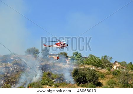 August 21 2016-Monti Prenestini-Castel San Peter- Roma-Lazio-Italy-the helicopter of the fire brigade to put out an arson attack on the slopes Prenestini who is skirting the first inhabited houses