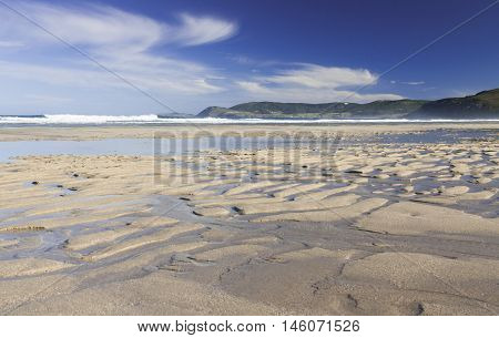 Spain Galicia Atlantic Ocean Beach low tide distant cliffs sunlit morning