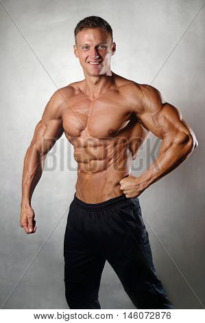 Fitness strength training workout bodybuilding concept background - muscular bodybuilder man doing exercises in gym