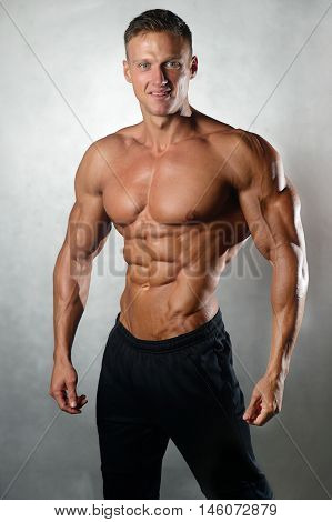 Fitness strength training workout bodybuilding concept background - muscular bodybuilder man doing exercises in gym