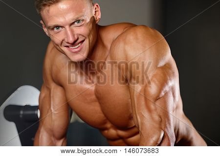 Handsome Muscular Bodybuilder Man Doing Exercises In Gym