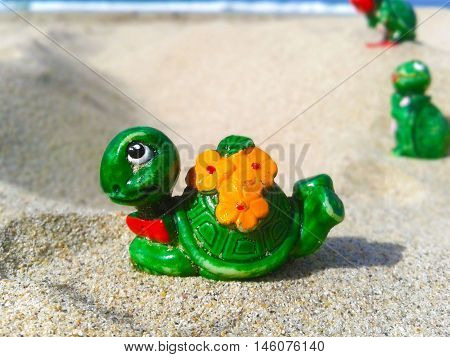 Nueva Esparta, Venezuela 07 september 2016. A little toy of a lady turtle with other turtles back on the beach sand