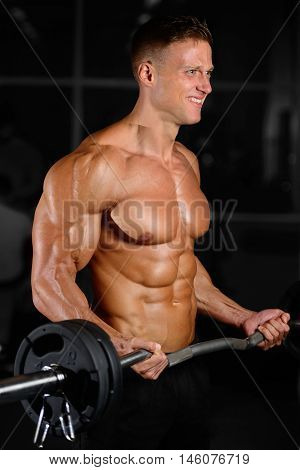 Handsome Muscular Bodybuilder Man Doing Exercises In Gym