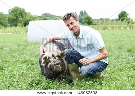 Portrait Of Farmer In Field With Pig