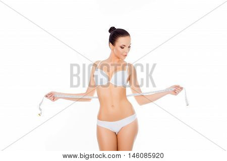 Young Woman In Lingerie Measuring Her Waist On White Background