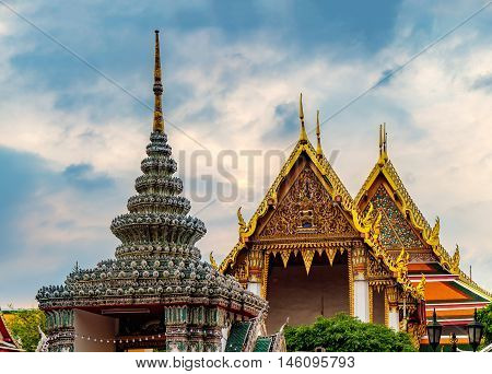 View of colorful rooftops of Temple of the Emerald Buddha or Wat Phra Kaew with cloudy sky Bangkok Thailand