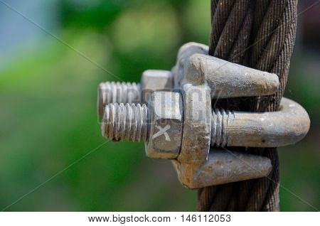 Big metal nut and bolt, marked with an X, locked on big metal wire