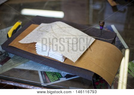 A bookbinder prepares to assemble a new journal.