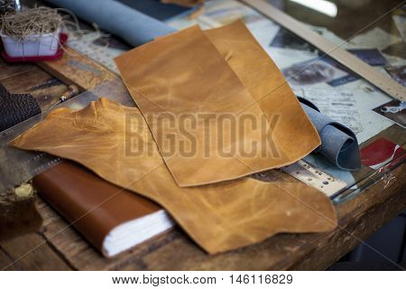 Cut leather and newly bound book rest at a bookbinders desk.