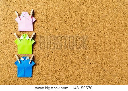 For beautiful background with cork board texture and origami shirt with wooden peg