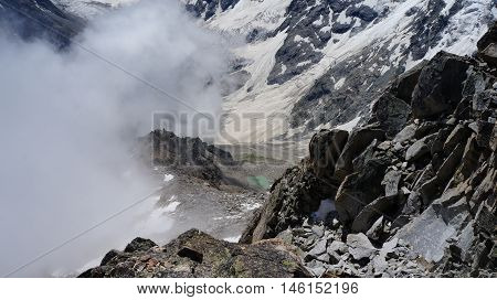 The Heart mountain lake and Mizhergi glacier as they viewed from the Brno peak duaring the ascent. Bezengi area of Central Caucasus, Russia.