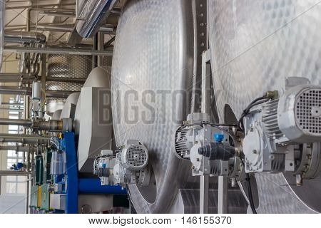 Stainless steel vessels and other equipment in workshop of primary grapes processing and primary fermentation in the modern winery