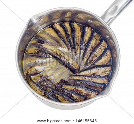 Smoked sprats cooked in vegetable oil in a stainless steel saucepan closeup on a light background
