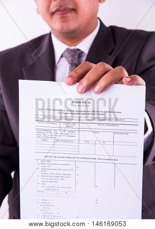 indian businessman showing indian income tax return form or ITR-4 form or form no. 16 of income tax department of india, selective focus