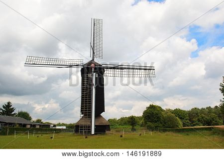 Typical dutch landscape with windmill and cloudy sky