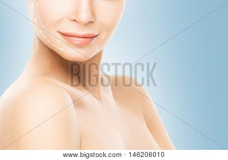 Close-up half face portrait of young, attractive woman with arrows on her face. Face lifting concept.