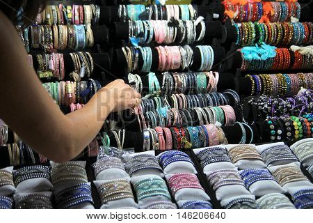 Frejus Port, France, 18 Aug 2016: A Woman Shops For Bracelets On A Warm Evening On A Market Stall In