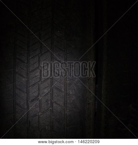 Car tires in a row on a shelf tire. Close-up in dark.