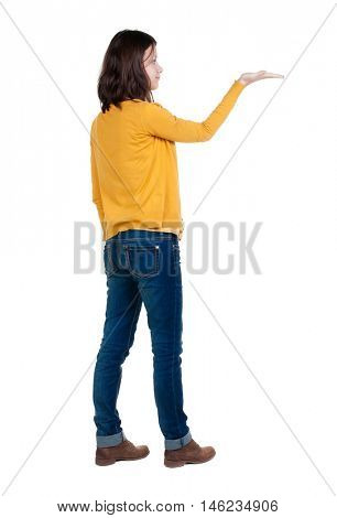 Back view of Beautiful business woman in yellow pulover looking at wall and Holds a hand up.  young brunette girl standing. Rear view people. Isolated over white background. 