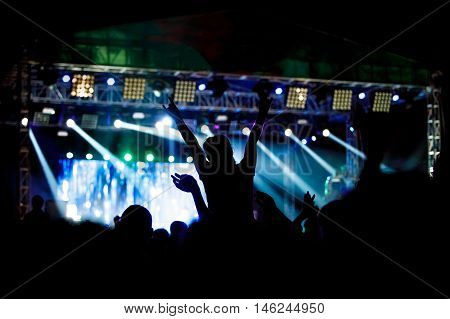 Black silhouette of young girl on rock concert, openair fest party