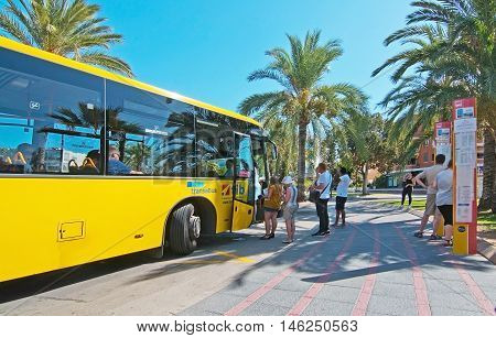 Passengers Boarding A Yellow Regional Bus
