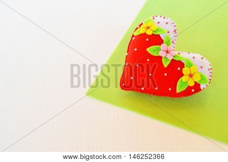 Home made felt heart. Symbol of Valentines Day. Handmade felt soft heart toy on white background